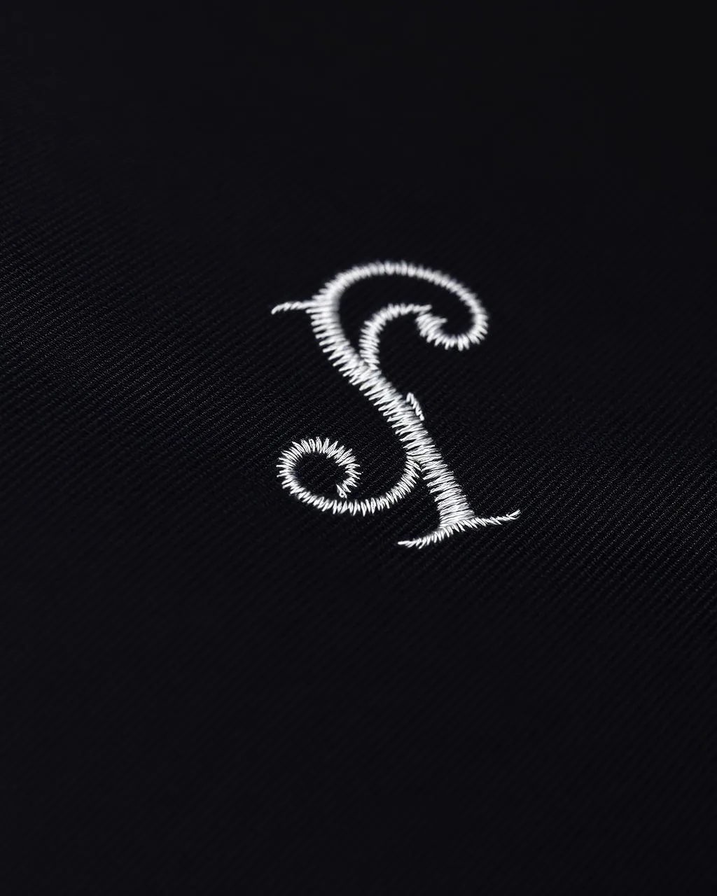 White embroidered monogram on black fabric